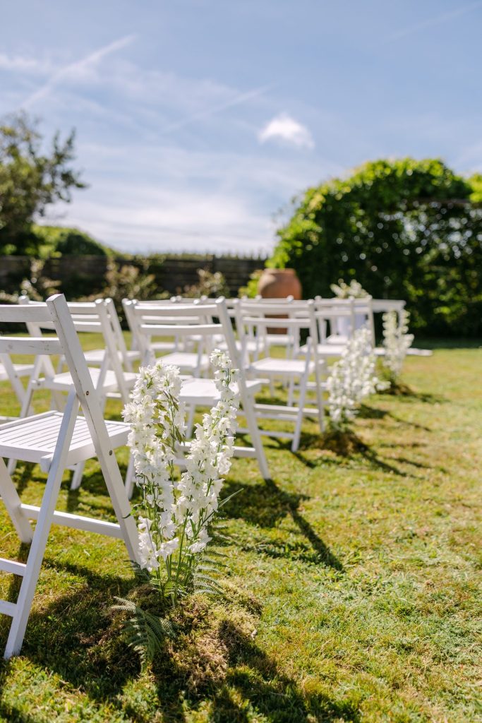 Pasillo de ceremonia con flores blancas en un jardín de Galicia