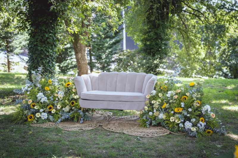 Rincón con sofá y flores en el jardín de una boda en Galicia